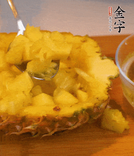 菠蘿對(duì)半切開(kāi)，切成小方格，用勺子把菠蘿肉挖出來(lái)。用鹽水稍浸泡。