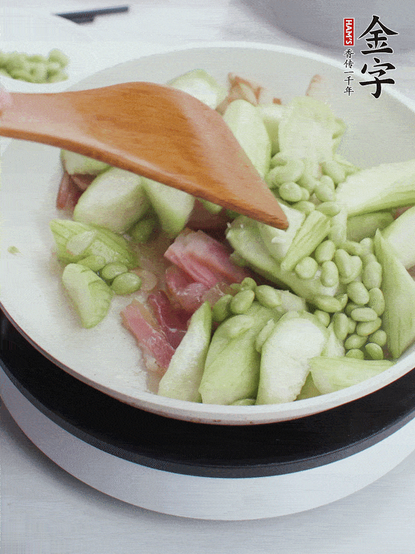 依次下絲瓜、青豆翻炒，炒至絲瓜打蔫縮小。