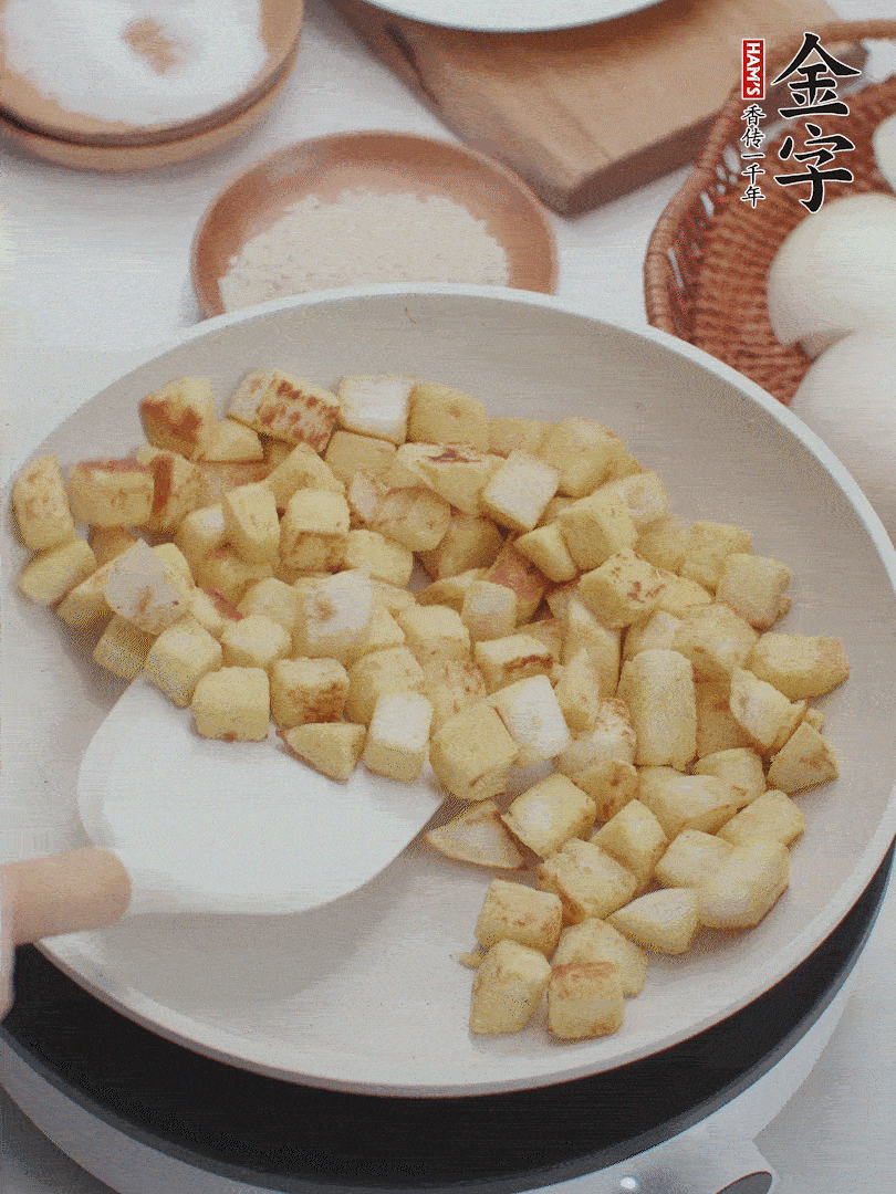 起鍋熱油，倒入饅頭丁，小火煎至蛋液凝固定型再翻面，饅頭丁部煎至金黃時盛起待用。