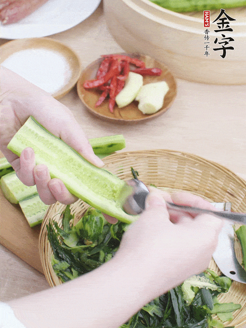 黃瓜削皮，對(duì)半切開，勺子挖去內(nèi)瓤，斜刀切片。青蒜斜刀切段。