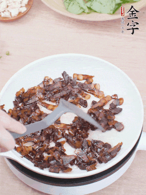 起鍋熱油，煸香醬油肉，撥拉到一邊。