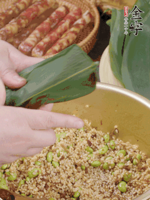 粽葉往下折，完全蓋住，兩側(cè)捏緊。