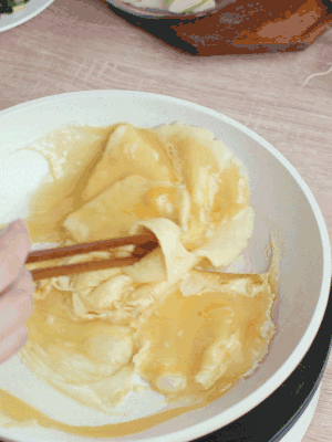 油6成熱時(shí)，下雞蛋液，邊緣凝固時(shí)翻拌成塊狀。