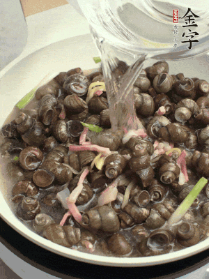倒處理干凈的螺螄翻炒，加3勺料酒。加清水蓋過螺螄，中火蓋蓋煮5分鐘。