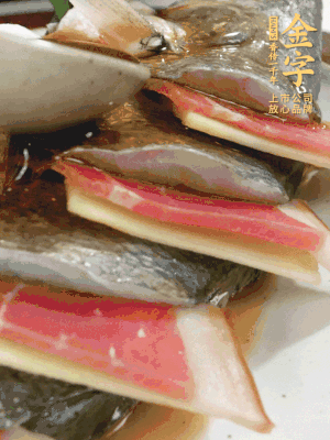 魚肚中塞蔥結(jié)、火腿片，魚身上碼放姜片、火腿片，倒入混合的料汁。