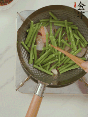 下掰好的缸豆段翻炒，略燜煮。
