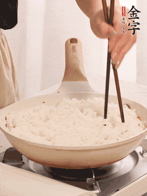把瀝干水分的米飯均勻鋪在上面，筷子戳幾個洞，以便透氣，轉(zhuǎn)小火蓋上蓋子燜至水分收干，大概10分鐘。